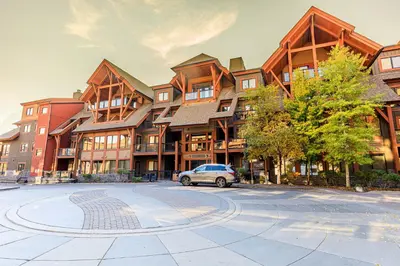 a car parked in front of a large building at Evergreen at Solara Resort in Canmore