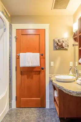 a bathroom with a wooden door and a sink at Evergreen at Solara Resort in Canmore