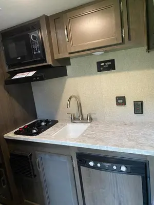 a kitchen with a sink and a microwave at Warm new Jayco trailer with comfy queen bed in Aldergrove