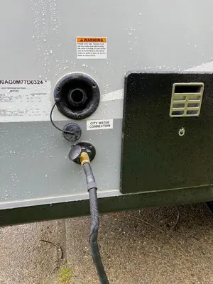 a gas tank with a hose plugged into it at Warm new Jayco trailer with comfy queen bed in Aldergrove