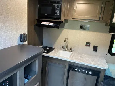 a small kitchen with a sink and a microwave at Warm new Jayco trailer with comfy queen bed in Aldergrove