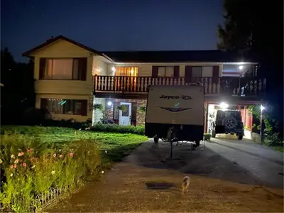 a sign in front of a house at night at Warm new Jayco trailer with comfy queen bed in Aldergrove