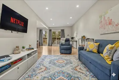 a living room with a blue couch and a tv at Entire Home - 2 Separate Units in Calgary