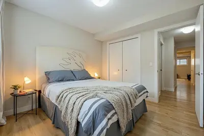 a bedroom with a large bed with blue pillows at Entire Home - 2 Separate Units in Calgary