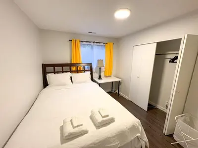 a bedroom with a bed with two towels on it at Vancouver UBC 3BD Garden Suite in Vancouver