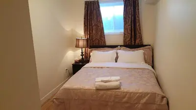 a bedroom with a bed with two towels on it at Modern 2 BR Vacation Home Near West Edmonton Mall in Edmonton