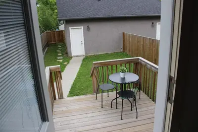 a porch with a table and chairs on a deck at Modern 2 BR Vacation Home Near West Edmonton Mall in Edmonton