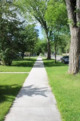 a sidewalk in a park with trees and grass at Modern 2 BR Vacation Home Near West Edmonton Mall in Edmonton