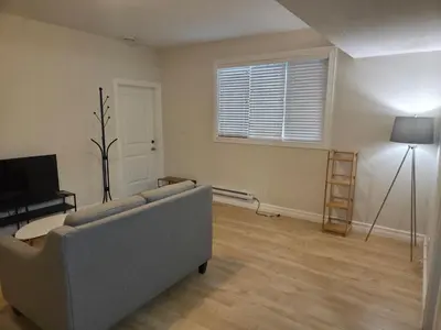 a living room with a couch and a television at Modern 2 Bedroom Suite Private & Fully Furnished in Prince George
