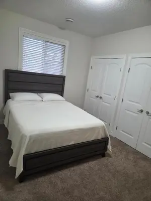 a bedroom with a large bed and white cabinets at Modern 2 Bedroom Suite Private & Fully Furnished in Prince George