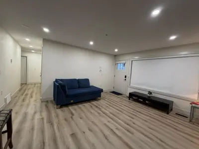 a living room with a blue couch and a large white screen at Vancouver Downtown Apartment - Walk to SkyTrain & BC Place, Free Parking in Vancouver