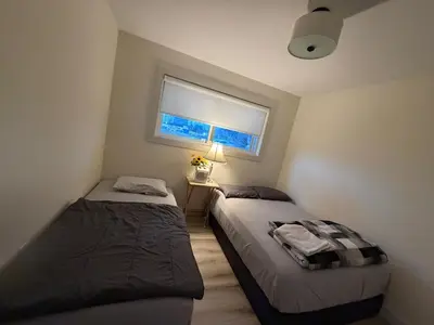 two beds in a small room with a window at Vancouver Downtown Apartment - Walk to SkyTrain & BC Place, Free Parking in Vancouver