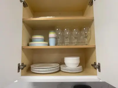 a cupboard with plates and glasses and dishes at 4615 Inverness Street Vancouver King And Queen size 2 Bedrooms Suite with Private Entry in Vancouver