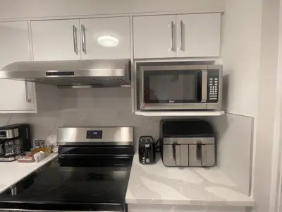 a kitchen with a microwave and a stove top oven at 4615 Inverness Street Vancouver King And Queen size 2 Bedrooms Suite with Private Entry in Vancouver