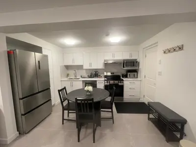 a kitchen with a table with chairs and a refrigerator at 4615 Inverness Street Vancouver King And Queen size 2 Bedrooms Suite with Private Entry in Vancouver