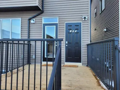a house with a black door and a fence at Modern 2BR Suite with Private Yard in Calgary