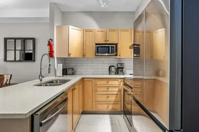 a kitchen with wooden cabinets and a sink at Cedar and Stone - 2 Bed 2 Bath Condo with Heated Pool and Hot Tub in Canmore