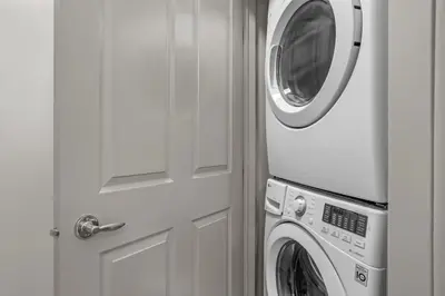 a washer and dryer sitting next to a door at Cedar and Stone - 2 Bed 2 Bath Condo with Heated Pool and Hot Tub in Canmore