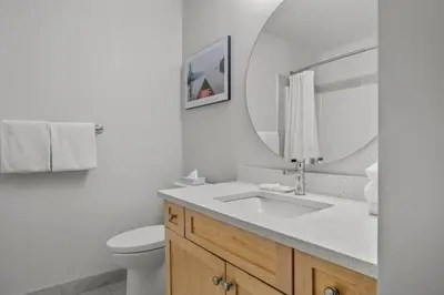 a bathroom with a sink and a toilet and a mirror at Cedar and Stone - 2 Bed 2 Bath Condo with Heated Pool and Hot Tub in Canmore
