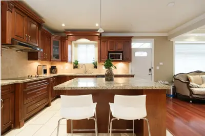 a kitchen with a large island with white bar stools at Cozy Room with Private Washroom in Central Location in Vancouver