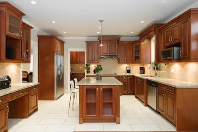 a large kitchen with wooden cabinets and a large island at Cozy Room with Private Washroom in Central Location in Vancouver