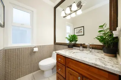 a bathroom with a sink and a toilet and a mirror at Cozy Room with Private Washroom in Central Location in Vancouver