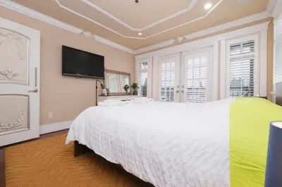 a bedroom with a white bed and a flat screen tv at Luxurious & Spacious Mansion next to Oakridge Mall in Vancouver