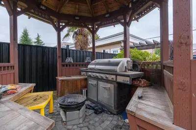 a outdoor kitchen with a grill and a wooden gazebo at Luxurious & Spacious Mansion next to Oakridge Mall in Vancouver