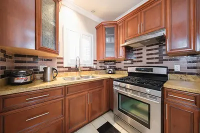 a kitchen with wooden cabinets and a stove top oven at Luxurious & Spacious Mansion next to Oakridge Mall in Vancouver
