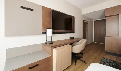 a hotel room with a desk and a television at Hyatt Place Vancouver/Metrotown in Burnaby