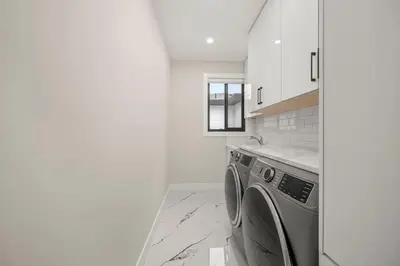 a white kitchen with a washing machine in it at Luxury 5BR Modern Home Huge Open Layout in Langley