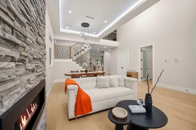 a living room with a white couch and a fireplace at Luxury 5BR Modern Home Huge Open Layout in Langley