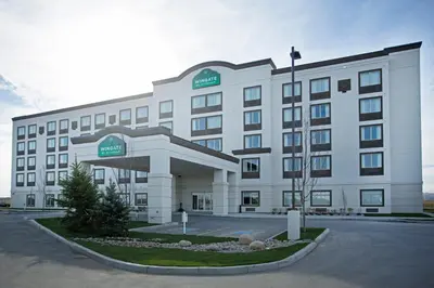 a large white building with a sign on it at Wingate by Wyndham Calgary Airport in Calgary