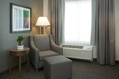 a hotel room with a chair and a window at Wingate by Wyndham Calgary Airport in Calgary