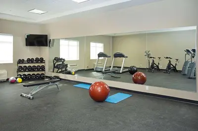 a gym with pilates equipment and a large mirror at Wingate by Wyndham Calgary Airport in Calgary