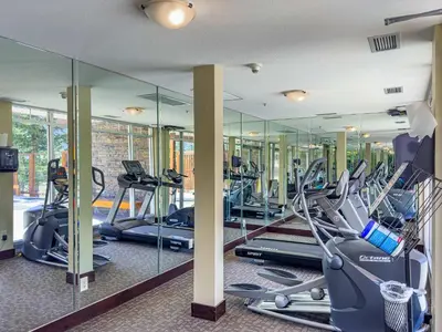 a gym with a bunch of treadmills and elliptical machines at Modern 1 Bedroom Retreat with Sofa Bed Comfort & Convenience Combined in Canmore