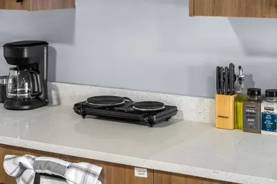 a black appliance sitting on a kitchen counter at 1BR Entertainment Space Projector and Games Room in Airdrie