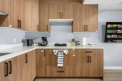 a kitchen with wooden cabinets and white counter tops at 1BR Entertainment Space Projector and Games Room in Airdrie