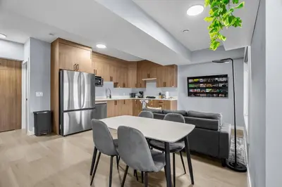 a kitchen with a table and chairs and a refrigerator at 1BR Entertainment Space Projector and Games Room in Airdrie