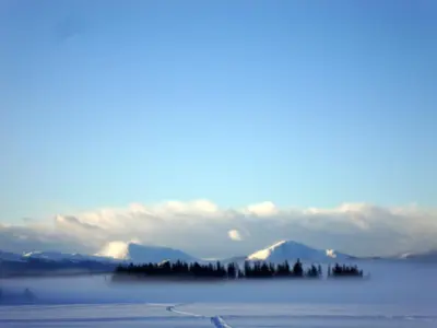 a view of a body of water with mountains in the background at Retreat Wilderness Inn in Nimpo Lake