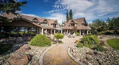 a large house with a landscaped yard at Retreat Wilderness Inn in Nimpo Lake