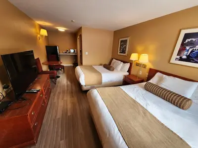 a hotel room with two beds and a flat screen tv at Fox Creek Inn in Fox Creek