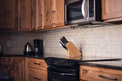 a kitchen counter with a knife block and a microwave at Arnica Chalet 2bd 2bath Ski In Out Silver Star in Vernon