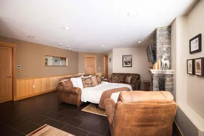 a bedroom with a bed and two chairs at Arnica Chalet 2bd 2bath Ski In Out Silver Star in Vernon
