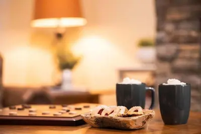 a table with two cups of coffee and a piece of bread at Arnica Chalet 2bd 2bath Ski In Out Silver Star in Vernon