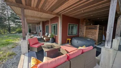 a screened in porch with a large couch and chairs at 'The Lookout' Sea View Suite w Hot tub in Shirley