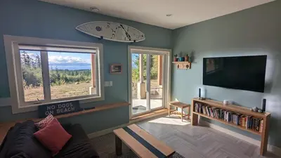 a living room with a couch and a flat screen tv at 'The Lookout' Sea View Suite w Hot tub in Shirley