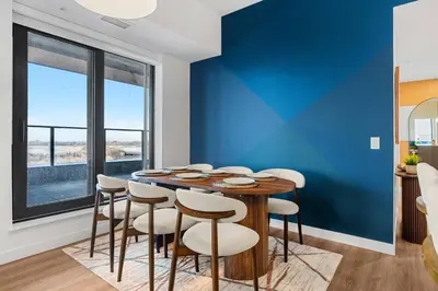 a dining room with a blue wall and a table and chairs at Dt Spacious and Vibrant | Kng Bed| Outdoor patio in Calgary