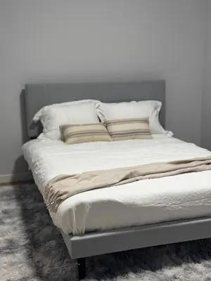 a bed with white sheets and pillows on it at Cozy 1bedroom Mainfloor in Calgary
