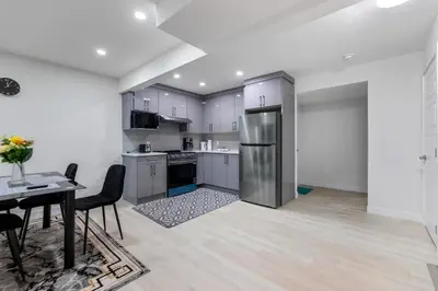a kitchen with a table and a stainless steel refrigerator at Brand New 3 Bedroom, 2 Washroom, Kitchen and Ensuite in Chestermere